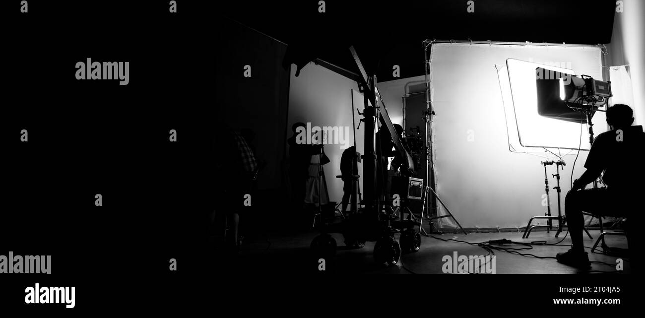 Immagini di silhouette della realizzazione o del dietro le quinte della produzione video prodotta nello studio cinematografico, che includono tutte le apparecchiature professionali di illuminazione e telecamera Foto Stock