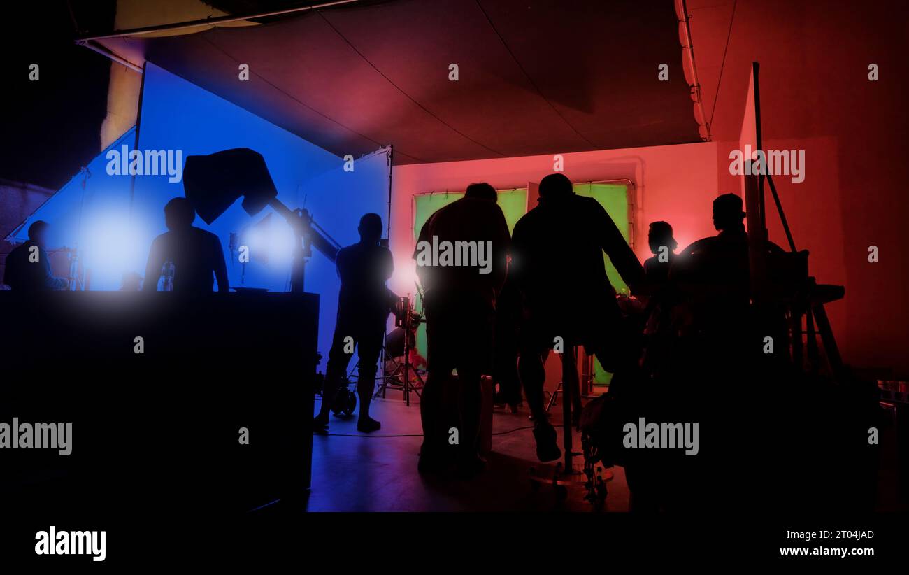 Immagini di silhouette della realizzazione o del dietro le quinte della produzione video prodotta nello studio cinematografico, che includono tutte le apparecchiature professionali di illuminazione e telecamera Foto Stock
