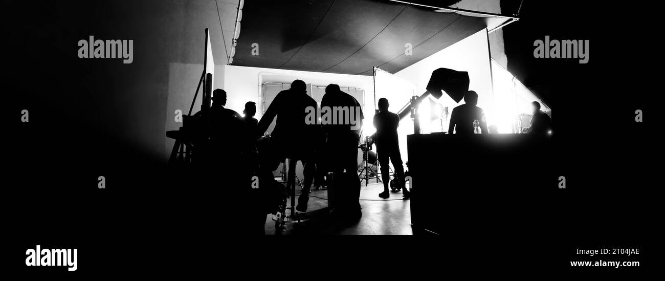 Immagini di silhouette della realizzazione o del dietro le quinte della produzione video prodotta nello studio cinematografico, che includono tutte le apparecchiature professionali di illuminazione e telecamera Foto Stock