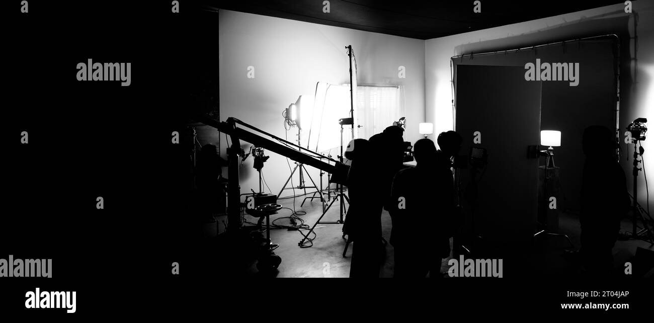 Immagini di silhouette della realizzazione o del dietro le quinte della produzione video prodotta nello studio cinematografico, che includono tutte le apparecchiature professionali di illuminazione e telecamera Foto Stock