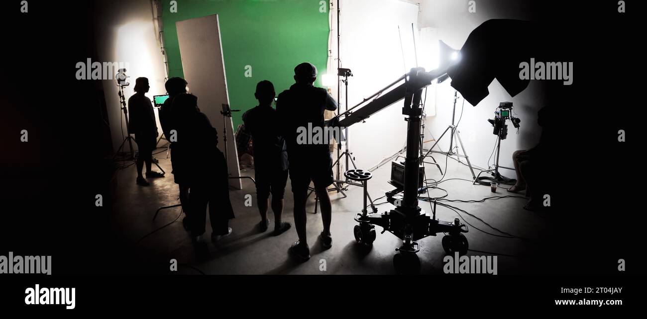 Immagini di silhouette della realizzazione o del dietro le quinte della produzione video prodotta nello studio cinematografico, che includono tutte le apparecchiature professionali di illuminazione e telecamera Foto Stock