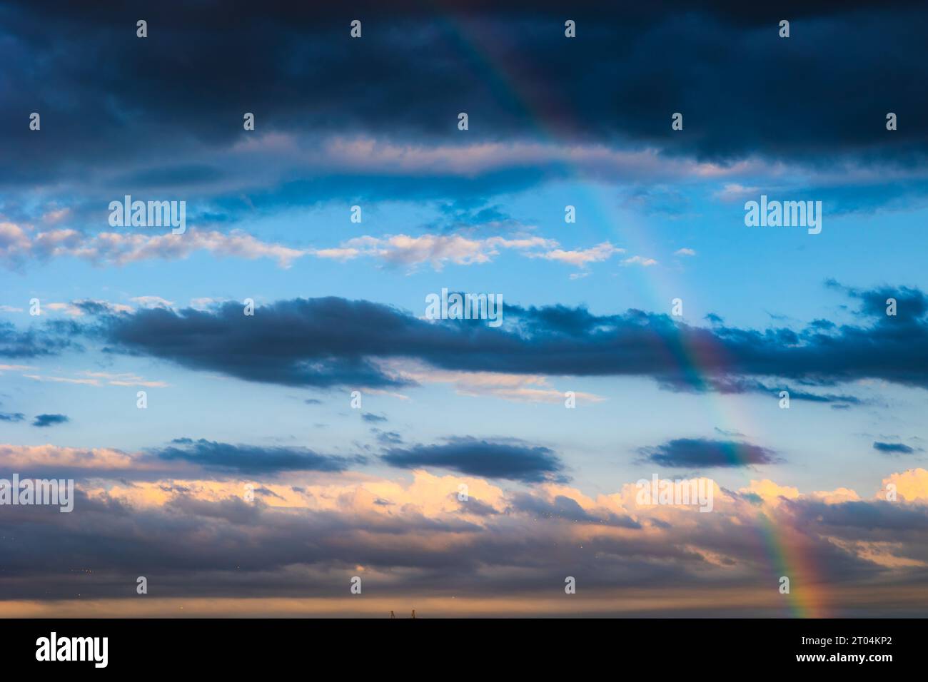 Arcobaleno e cielo parzialmente nuvoloso sullo sfondo. Foto di sfondo tempo piovoso. Foto Stock