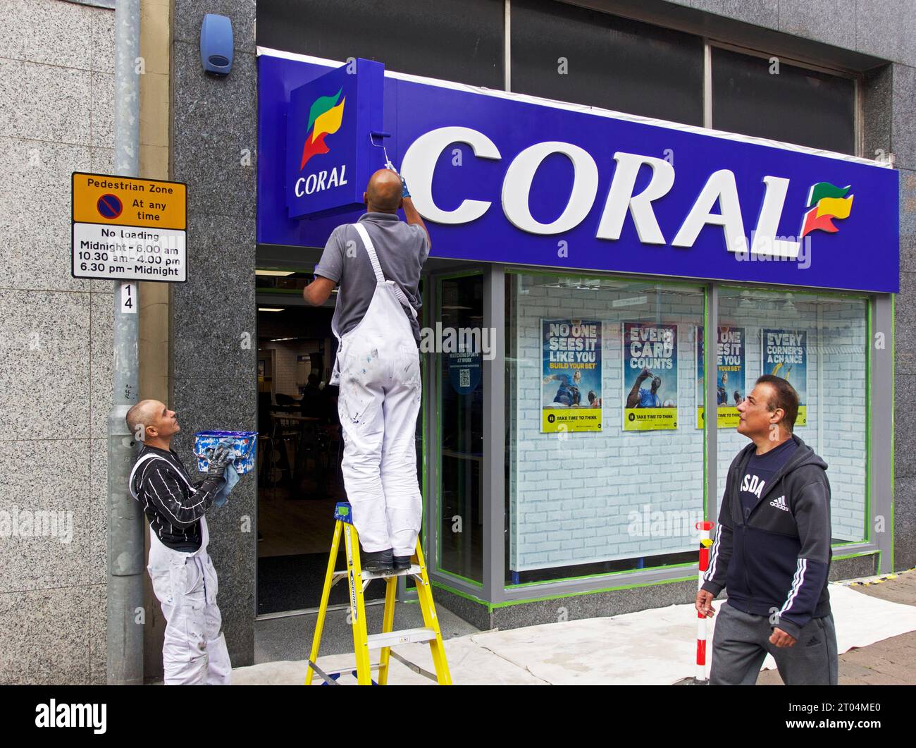 Due uomini che dipingono l'insegna sul negozio di scommesse di Coral, a Castleford, West Yorkshire, Inghilterra, Regno Unito Foto Stock