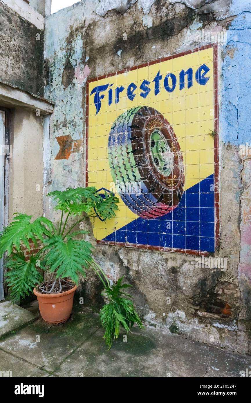 Vecchia pubblicità di pneumatici Firestone realizzati con piastrelle. La struttura vintage si trova in una parete esterna con agenti atmosferici. Santa Clara, Cuba, 2023 Foto Stock