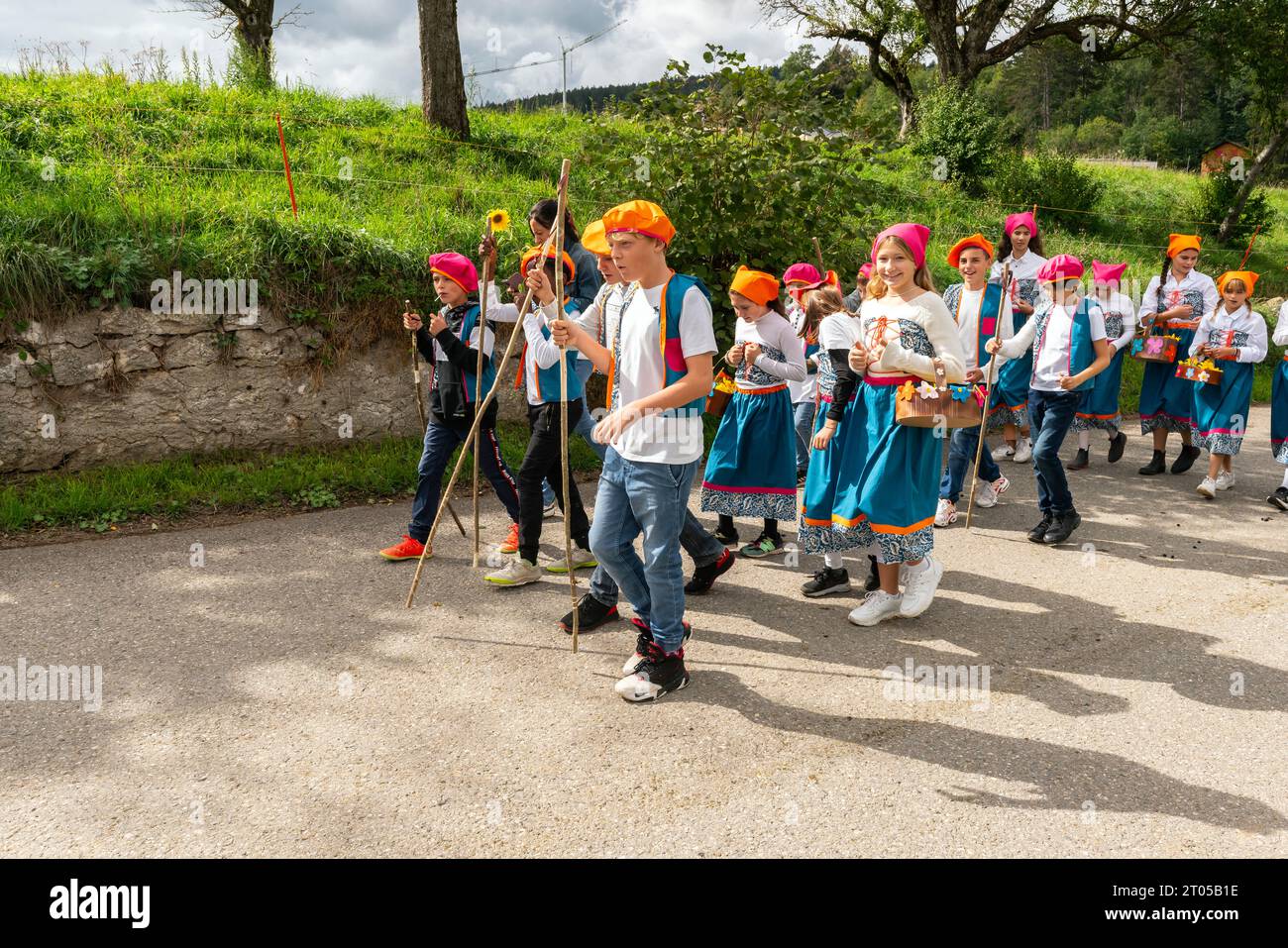 Gli abitanti del villaggio vestiti con costumi tradizionali prendono parte con orgoglio all'annuale parata delle mucche alpine nel villaggio di Ligniéres, sulle montagne del Giura, in Svizzera. Foto Stock