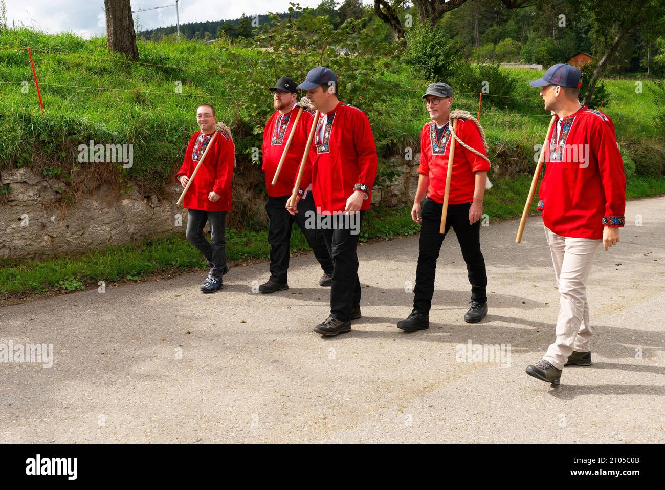 Gli abitanti del villaggio vestiti con costumi tradizionali prendono parte con orgoglio all'annuale parata delle mucche alpine nel villaggio di Ligniéres, sulle montagne del Giura, in Svizzera. Foto Stock