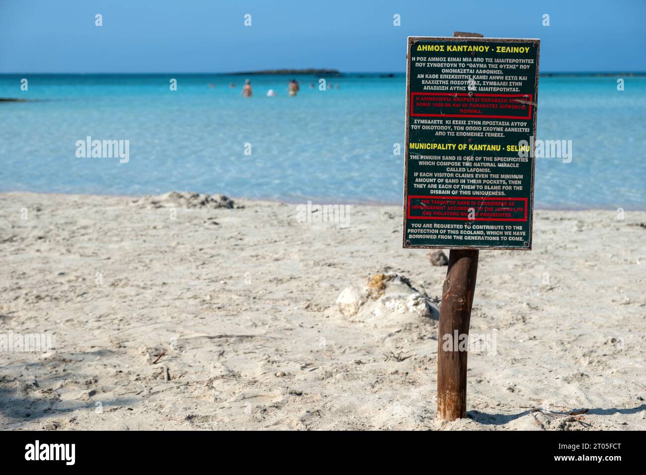 Cartello di legno informare sull'isola di Elafonisi, Creta, Grecia. Messaggio per evitare di prendere la sabbia rosa dal miracolo della natura, spiaggia sabbiosa. Sfocatura del mare, dello spazio. Foto Stock