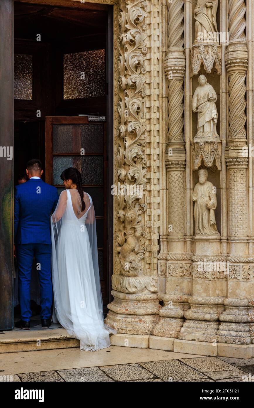 una sposa in abito da sposa bianco attende nella splendida porta della cattedrale di sibenik pronta a camminare lungo la navata Foto Stock