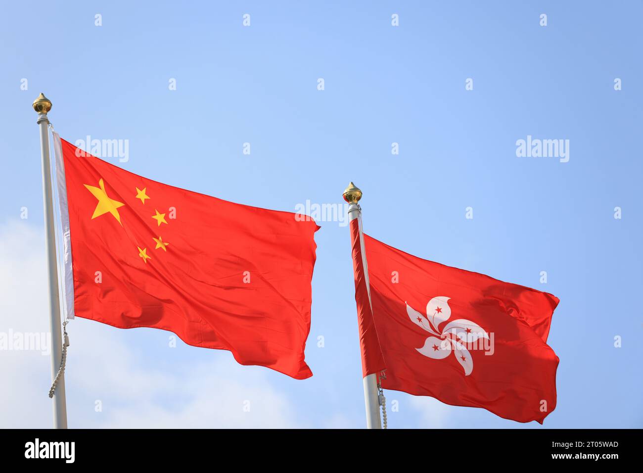 Bandiera cinese e di hong kong allestita in occasione della celebrazione del 74° anniversario della giornata nazionale della Repubblica Popolare Cinese contro i blu Foto Stock