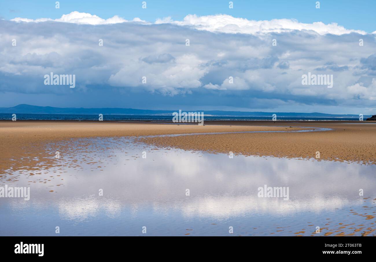 Ampia spiaggia di sabbia vuota con bassa marea nella riserva naturale di Aberlady sulla riva Firth of Forth con riflessi nuvolosi in acqua, East Lothian, Scozia, Regno Unito Foto Stock