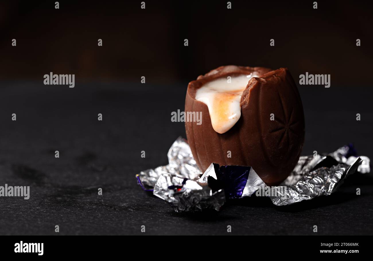L'uovo di Creme di Cadbury srotolato si sedeva sul suo foglio Foto Stock