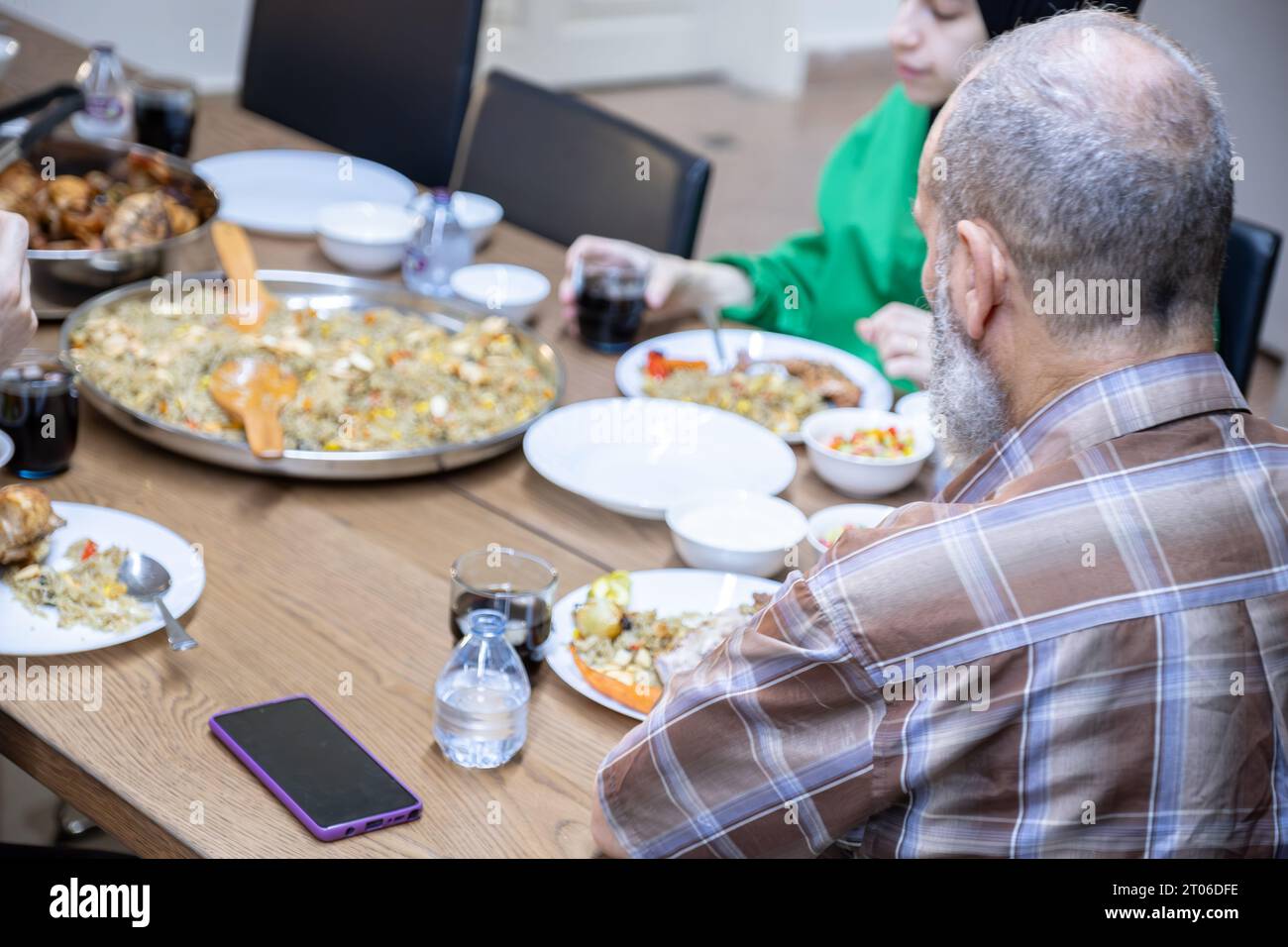 famiglia di più generazioni che mangia insieme al nonno Foto Stock