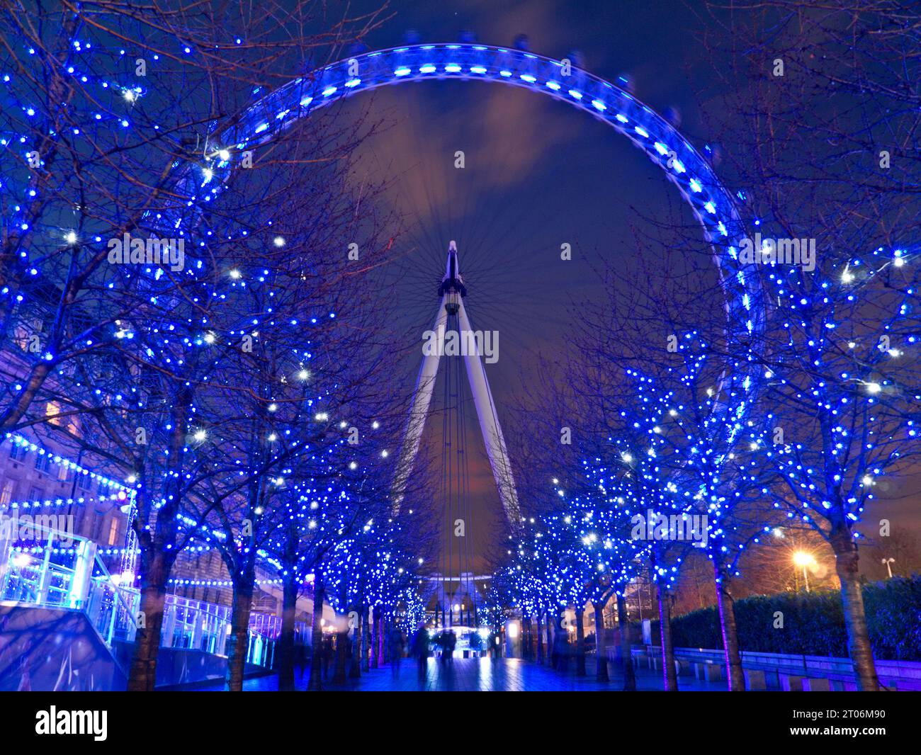 London Eye Millennium Wheel con luci blu scintillanti sugli alberi durante le festività natalizie sul viale pedonale di notte South Bank Londra, Inghilterra Regno Unito Foto Stock