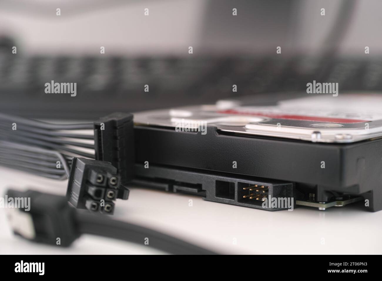 Un'unità disco rigido ad alta capacità nuova di zecca con SATA e cavi di alimentazione nelle vicinanze. Primo piano. Foto Stock