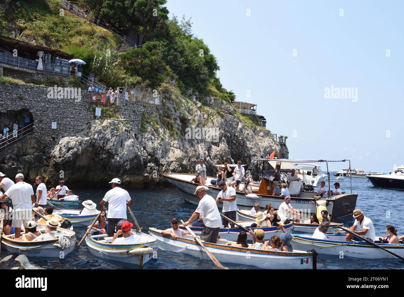 I turisti aspettano sulle barche a remi per entrare nella Grotta Azzurra, la più grande attrazione turistica dell'isola di Capri, a Napoli. Foto Stock