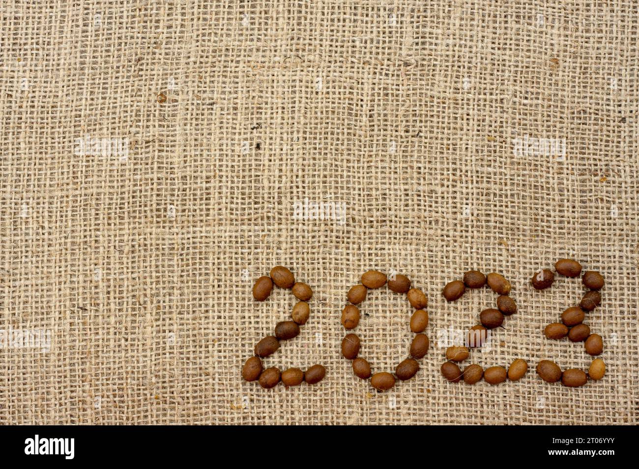 i numeri 2023 sono realizzati con chicchi di caffè su un tessuto con texture burlap. Vista dall'alto. Posiziona per testo. Sfondo per la progettazione. Foto Stock
