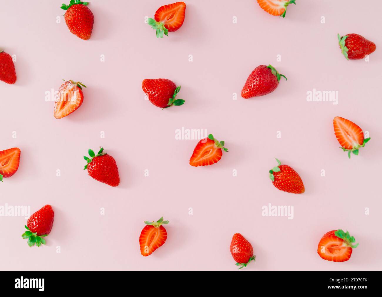 Fantasia di frutta alla moda fatta di fragole fresche e sane su sfondo rosa pastello chiaro. Natura creativa composizione minimale con motivo alle fragole. Foto Stock