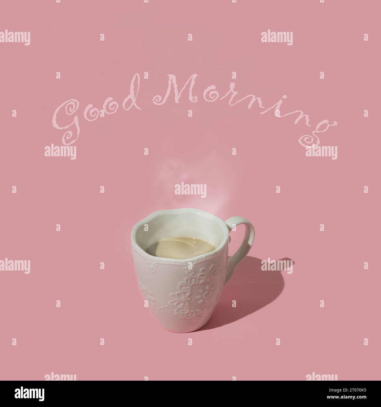 Composizione elegante fatta di caffè fumante su sfondo rosa pastello con messaggio del buon mattino. Concetto di caffè creativo minimale. Idea di sfondo alla moda Foto Stock