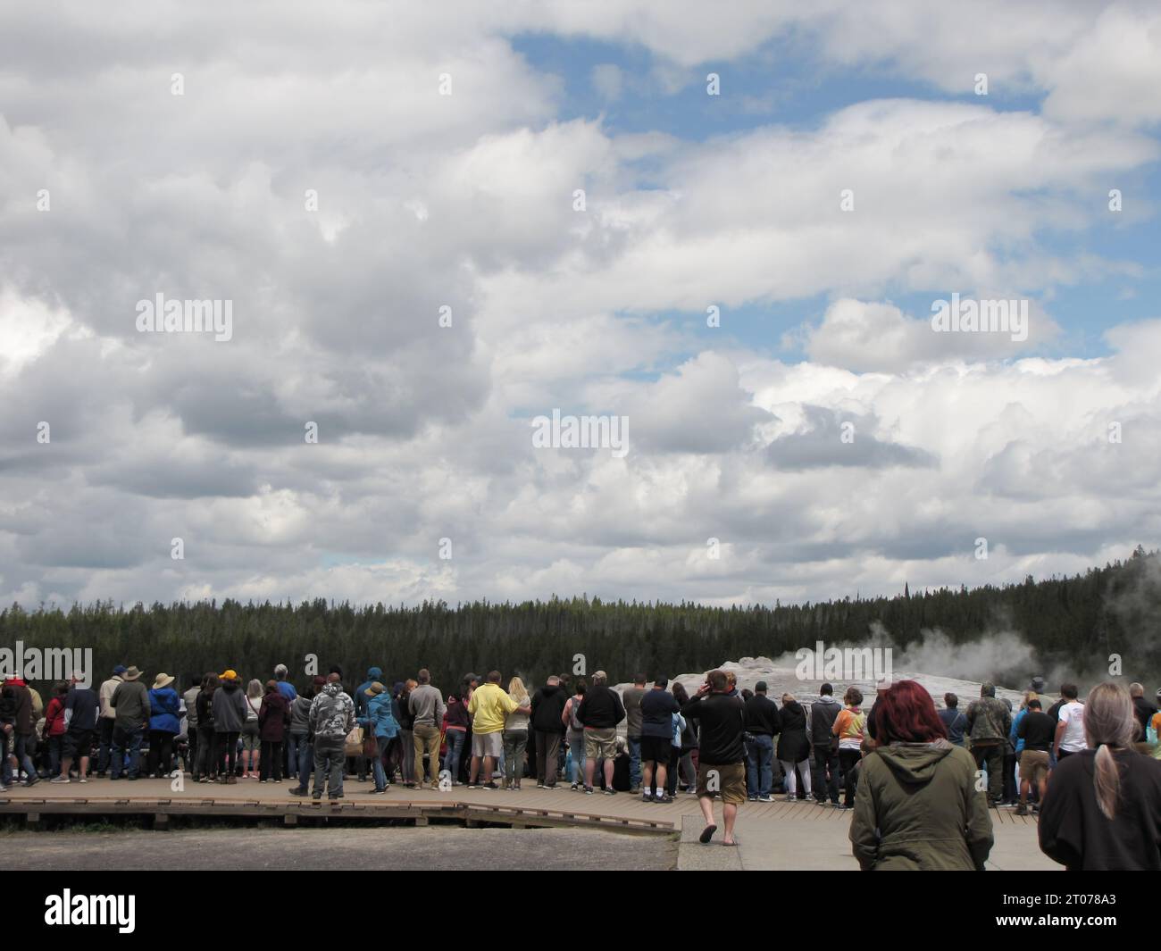 I turisti si sono riuniti sul lungomare nel parco nazionale di Yellowstone osservando il geyser e ascoltando l'istruzione dei ranger del parco. Foto Stock