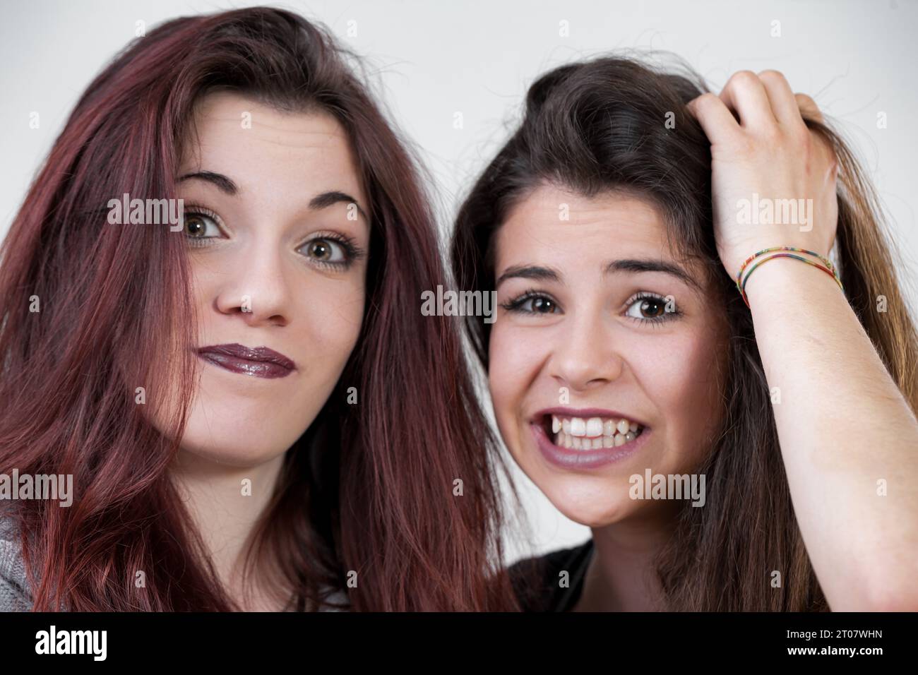 Queste due donne, vestite con trucco preciso e capelli lunghi, non si trattengono sul divertimento. Facendoli sembrare stupidi, incarnano il perfetto mix di eleganza A. Foto Stock