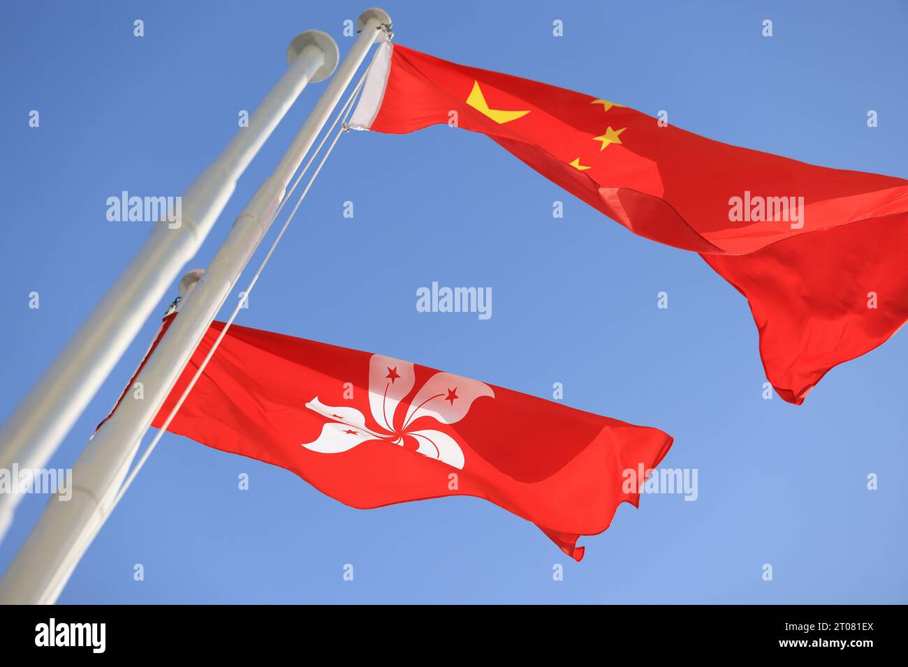 Bandiera cinese e di hong kong allestita in occasione della celebrazione del 74° anniversario della giornata nazionale della Repubblica Popolare Cinese contro i blu Foto Stock