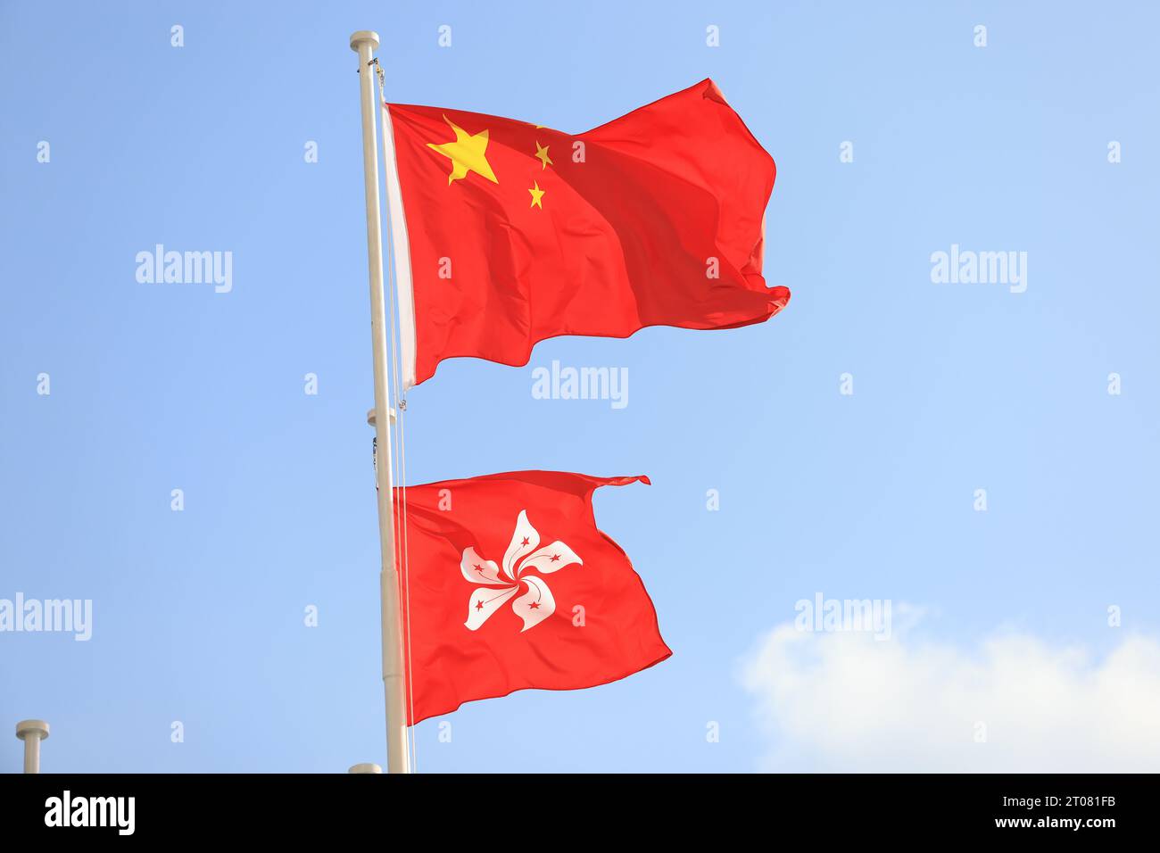 Bandiera cinese e di hong kong allestita in occasione della celebrazione del 74° anniversario della giornata nazionale della Repubblica Popolare Cinese contro i blu Foto Stock