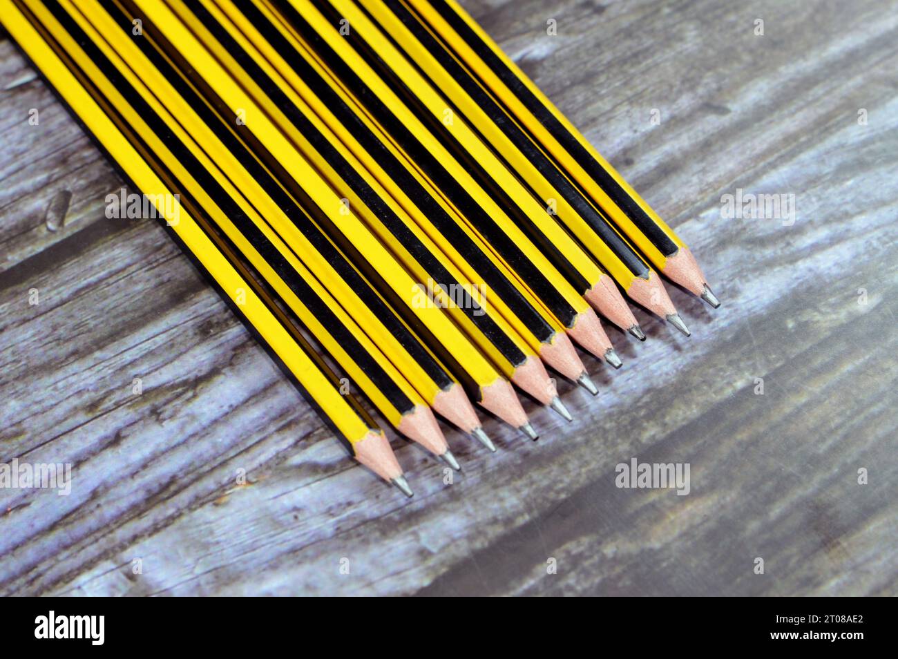 Fila di matite, una matita è un attrezzo per scrivere o disegnare con un nucleo pigmentato solido in un involucro protettivo che riduce il rischio di rottura del nucleo, AN Foto Stock
