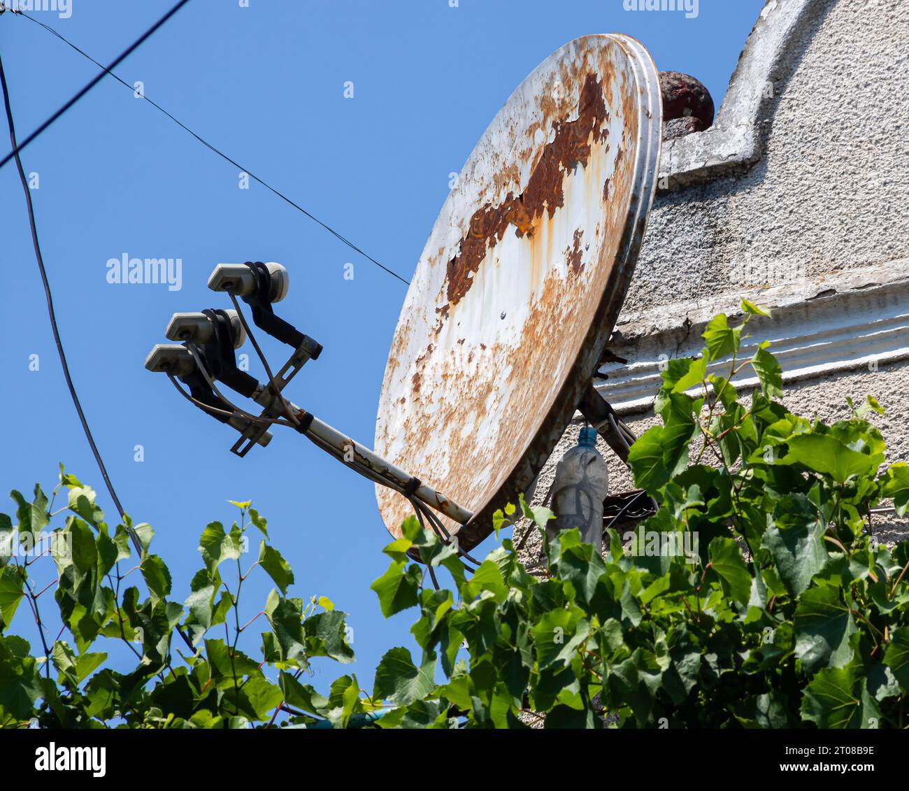 Antenna TV satellitare sulla parete esterna dell'edificio su uno sfondo di cielo Foto Stock