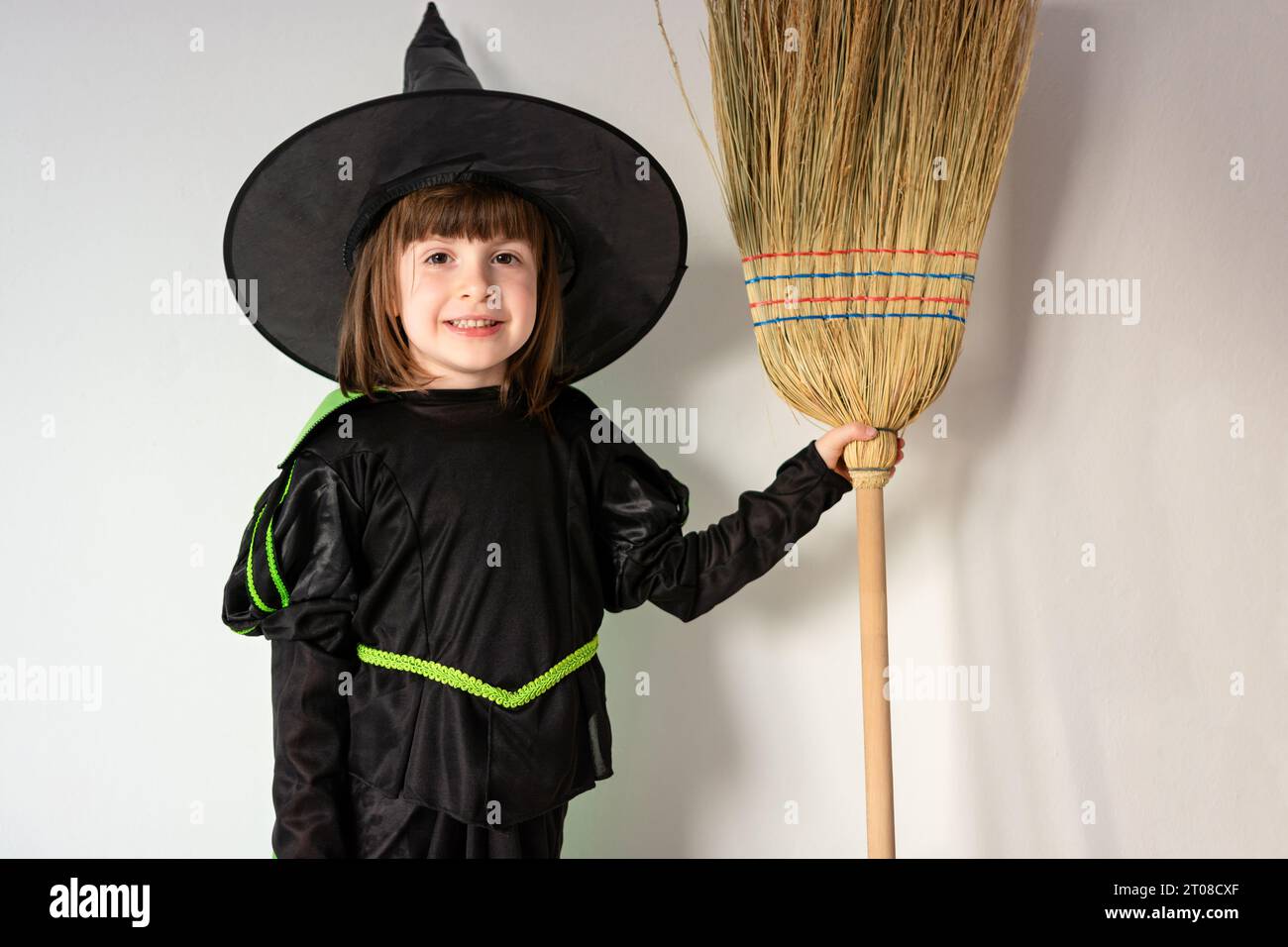 Bambina in costume strega seduta da anteriore a posteriore su una scopa  Foto stock - Alamy