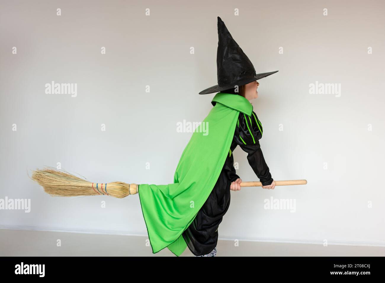 Foto integrale di una bambina vestita da strega per halloween mentre  cavalca una scopa Foto stock - Alamy