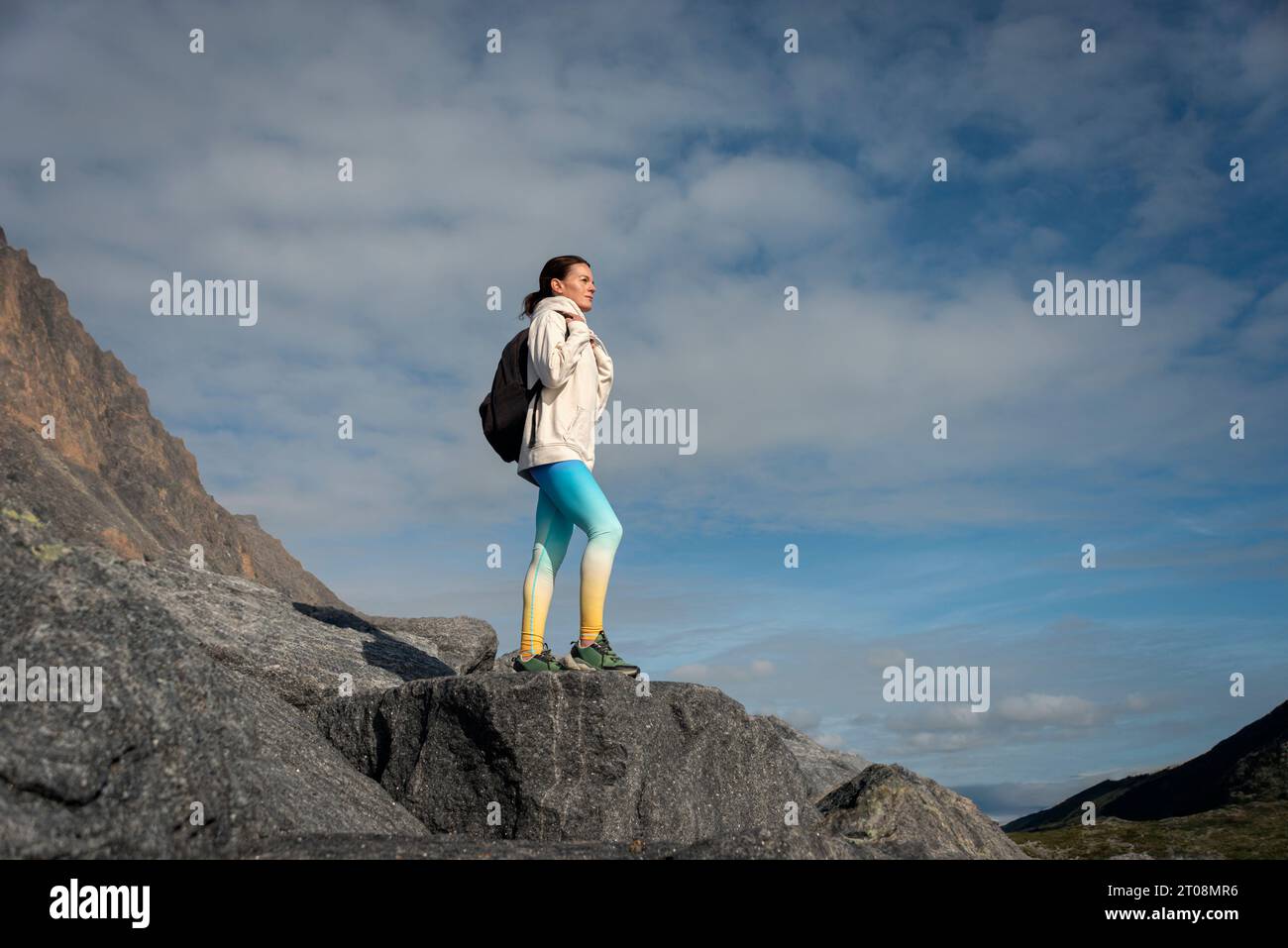 Una donna che cammina in montagna. Goditi la vista Foto Stock