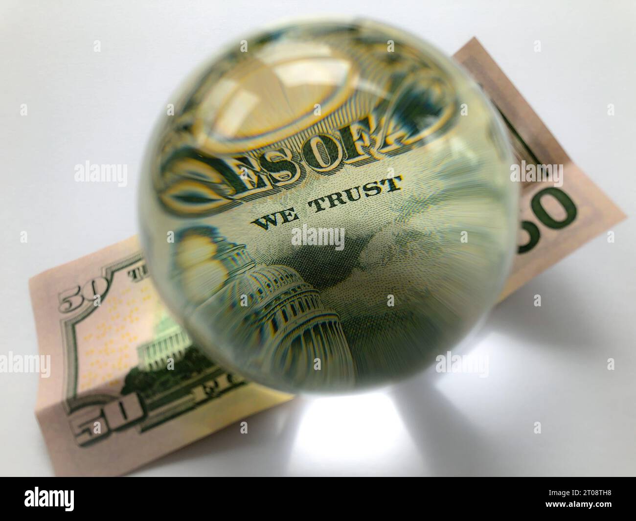 Banconota da 50 dollari vista attraverso una sfera di cristallo, attenzione selettiva sulle parole di cui ci fidiamo Foto Stock