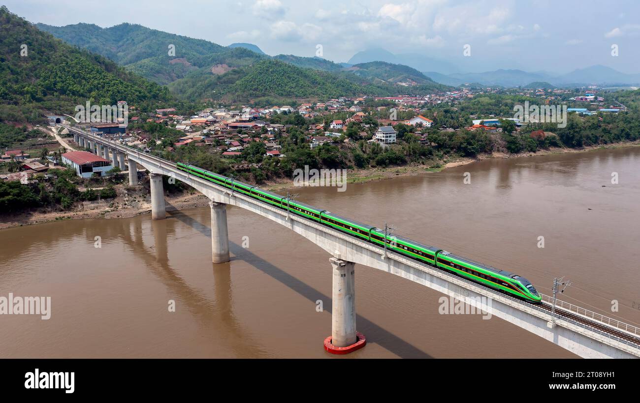 Pechino, Cina. 28 maggio 2023. Un treno guida sulla ferrovia cinese-Laos Luang Prabang attraversa il fiume Mekong super ponte principale in Laos, il 28 maggio 2023. Il ponte, circa 230 km a nord della capitale del Laos, Vientiane, ha una lunghezza totale di 1.458,9 metri ed è composto da 28 travi a T e sei travi continue. È il ponte più difficile e tecnicamente complesso dell'intera ferrovia. Crediti: Chen Chang/Xinhua/Alamy Live News Foto Stock