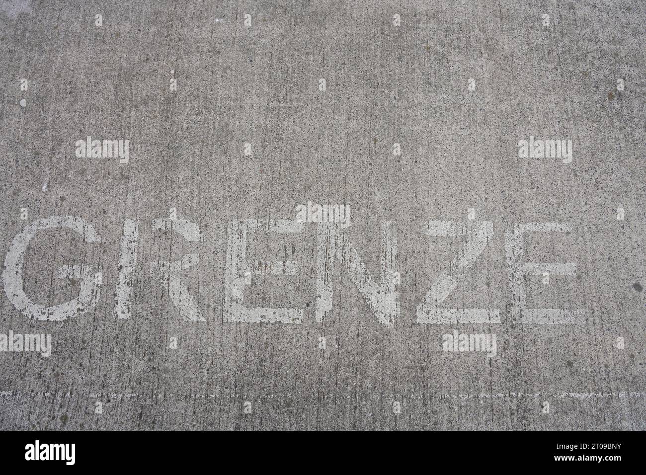 Bordo su sfondo grigio. Bordo delle lettere su una superficie di cemento. Foto Stock