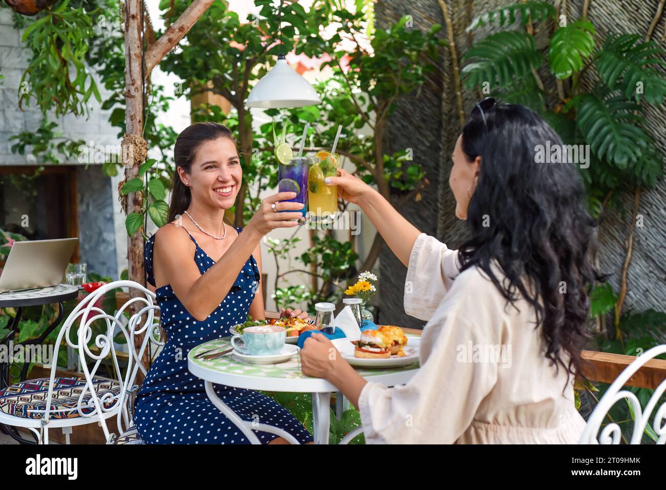 due bellissime amiche che si fanno beffe delle limonate per fare il tifo e che fanno colazione al bar Foto Stock