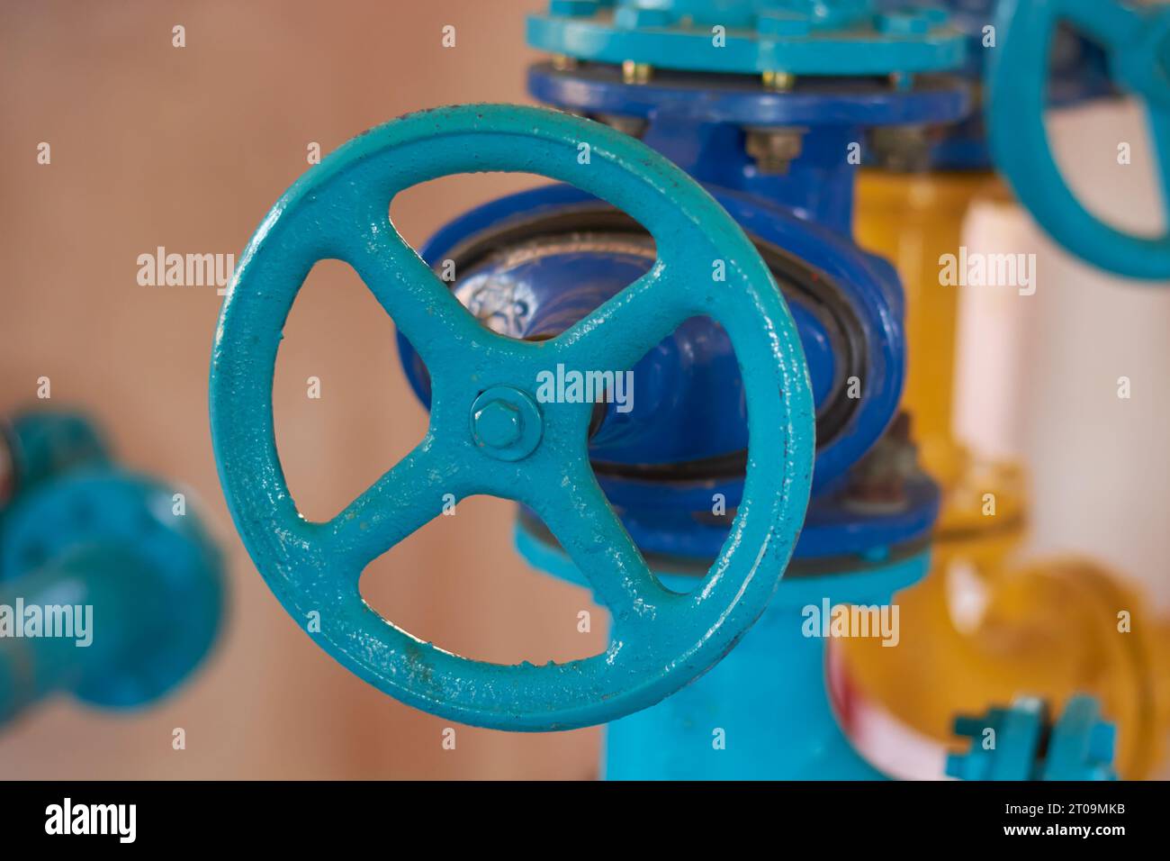 primo piano della valvola dell'acqua o del gas con tubo in acciaio, vecchia o antica valvola circolare o a saracinesca nel sistema di tubazioni, concetto di attrezzatura industriale preso in selectiv Foto Stock