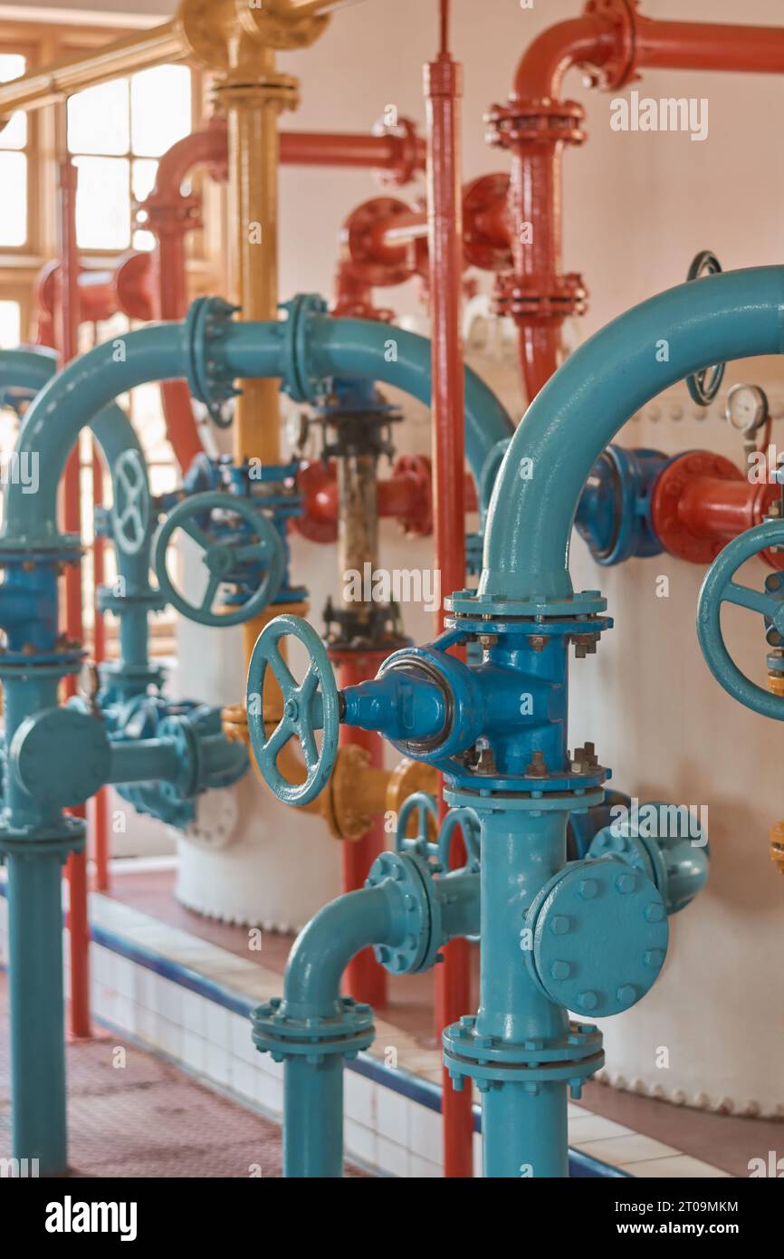 sistema di tubazioni in acciaio per acqua o gas vecchio o antico con valvole, concetto di apparecchiature industriali preso in orientamento verticale con messa a fuoco selettiva Foto Stock
