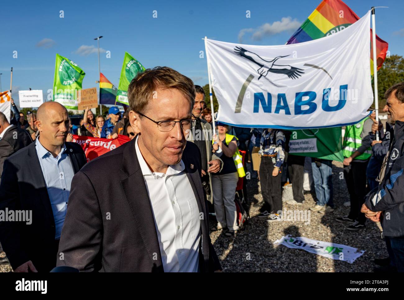 05 ottobre 2023, Schleswig-Holstein, Neumünster: Daniel Günther (CDU), ministro presidente dello Schleswig-Holstein, si trova di fronte ai manifestanti del Fridays for Future, BUND SH, Diving Association e Friends of Nature Association for the Baltic Sea National Park, di fronte alla riunione rappresentativa del CDU Schleswig-Holstein, sulla creazione di un parco nazionale del Mar Baltico. Foto: Axel Heimken/dpa Foto Stock