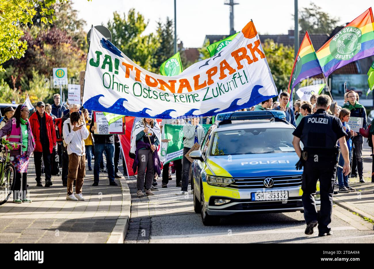 05 ottobre 2023, Schleswig-Holstein, Neumünster: I partecipanti a una dimostrazione di Fridays for Future, BUND SH, Diving Sports Association e Friends of Nature Association for the Baltic Sea National Park, portano uno striscione davanti all'edificio congressuale dell'assemblea rappresentativa del CDU Schleswig-Holstein con l'iscrizione "Sì! Parco nazionale. Nessun futuro senza Mar Baltico”. Foto: Axel Heimken/dpa Foto Stock