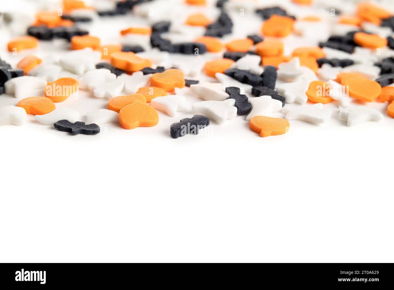 Gli spruzzi di Halloween si diffondono nel cuore, nei fantasmi e nelle forme dei pipistrelli, da vicino. Zucchero a tema Halloween arancione, nero e bianco cosparge per torte, cupcake e. Foto Stock