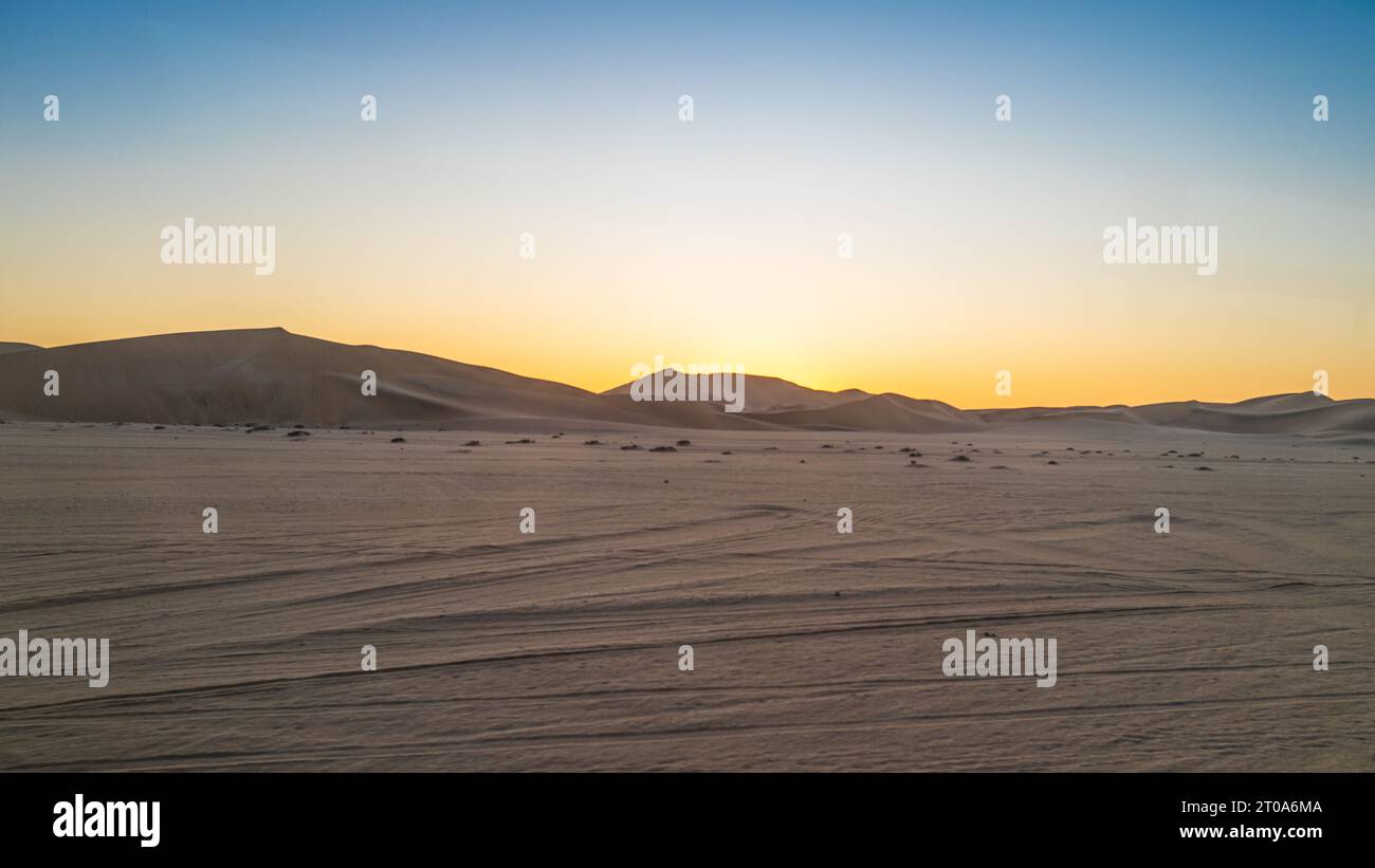 Una foto mattutina del sole che arriva sulle dune della Namibia Foto Stock