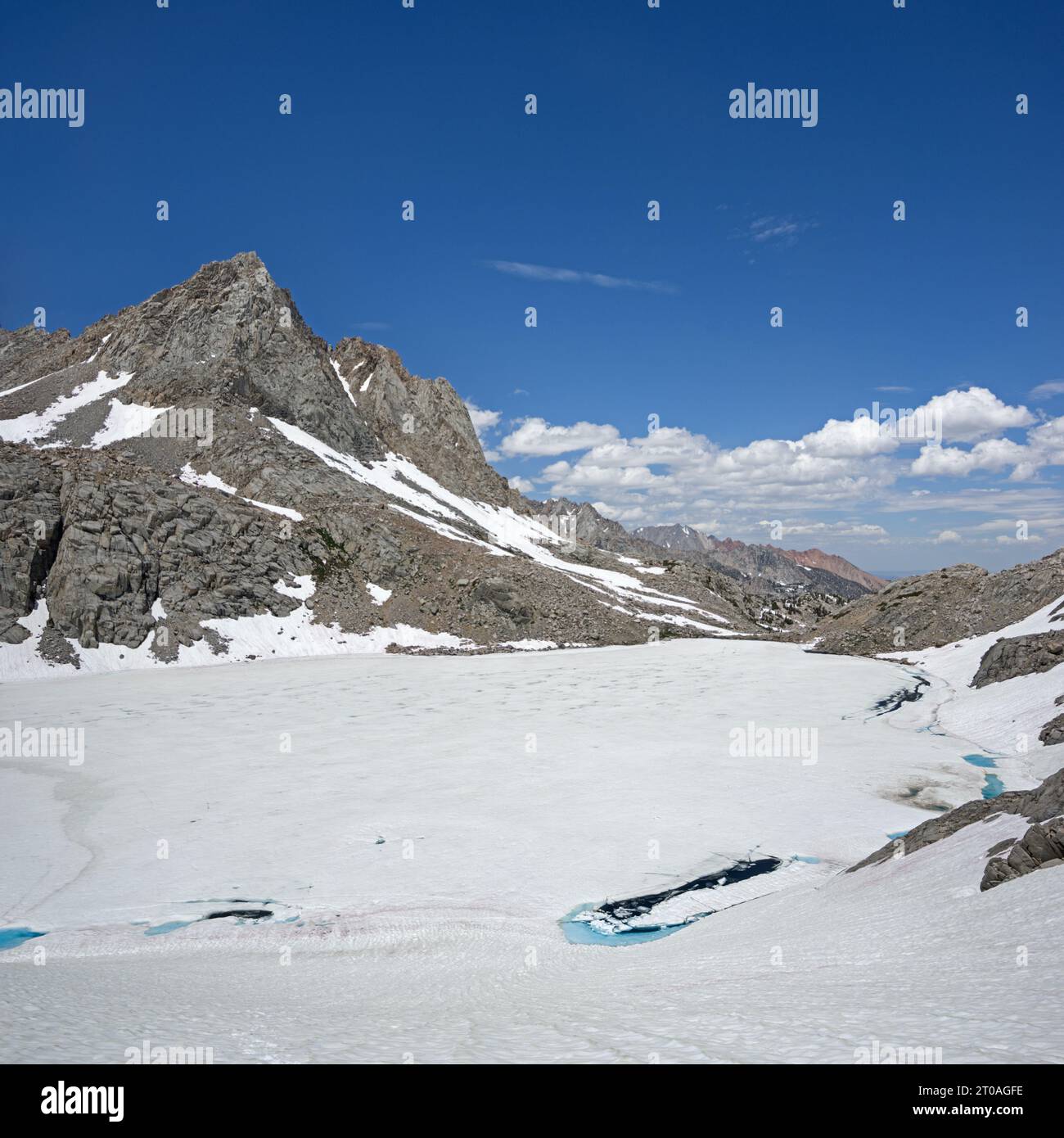 Picture Peak e un lago Echo per lo più ghiacciato nella John Muir Wilderness delle montagne della Sierra Nevada nel luglio di un anno di neve alta Foto Stock