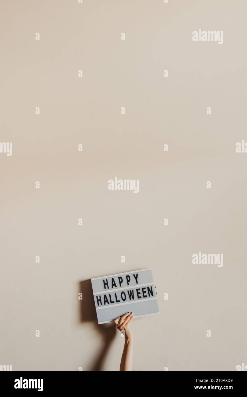 mano con un cartello di felice halloween Foto Stock
