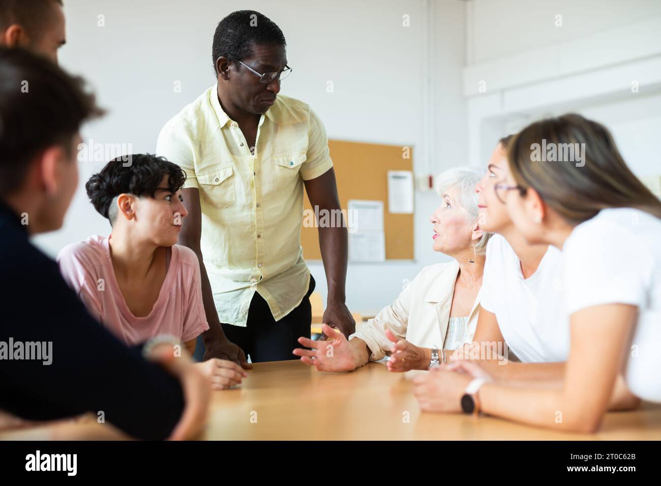 Gruppo multirazziale di età mista partecipante classe di istruzione per adulti con tutor afro-americano Foto Stock