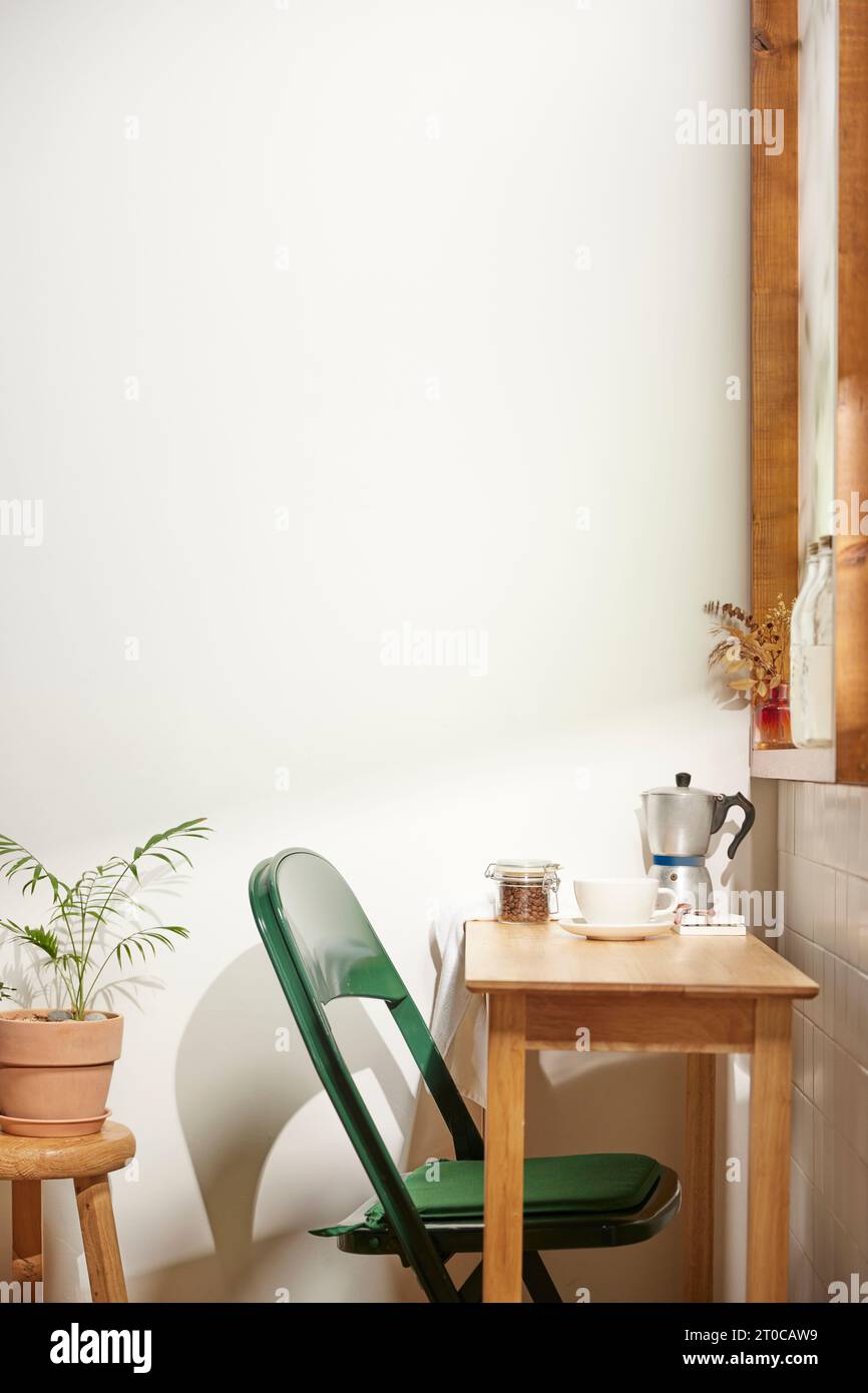 Una camera confortevole dove la calda luce del sole del pomeriggio entra attraverso una finestra con vista sulle foglie degli alberi. Foto Stock