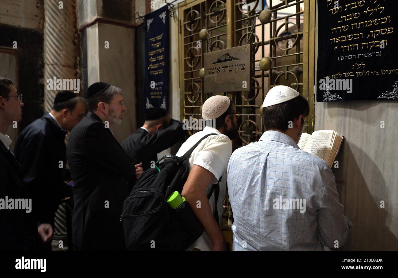 Gli ebrei religiosi pregano sul lato israeliano della Tomba dei Patriarchi, nota agli ebrei con il suo nome biblico Grotta di Machpelah e ai musulmani come al-Haram al-Ibrahimi, un sito che si crede sia il luogo di riposo finale del profeta Abramo, figura sacra per ebrei e musulmani, situato nel cuore della città vecchia di Hebron, in Israele. Foto Stock
