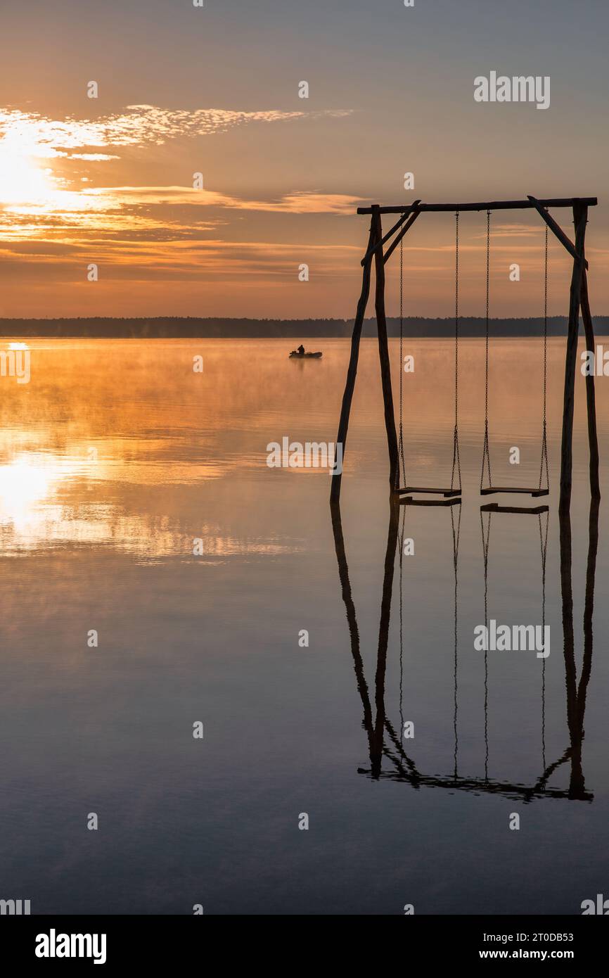 Vista sul romantico Lago bianco all'alba con altalena in legno nella regione di Rivne, Ucraina. Foto Stock