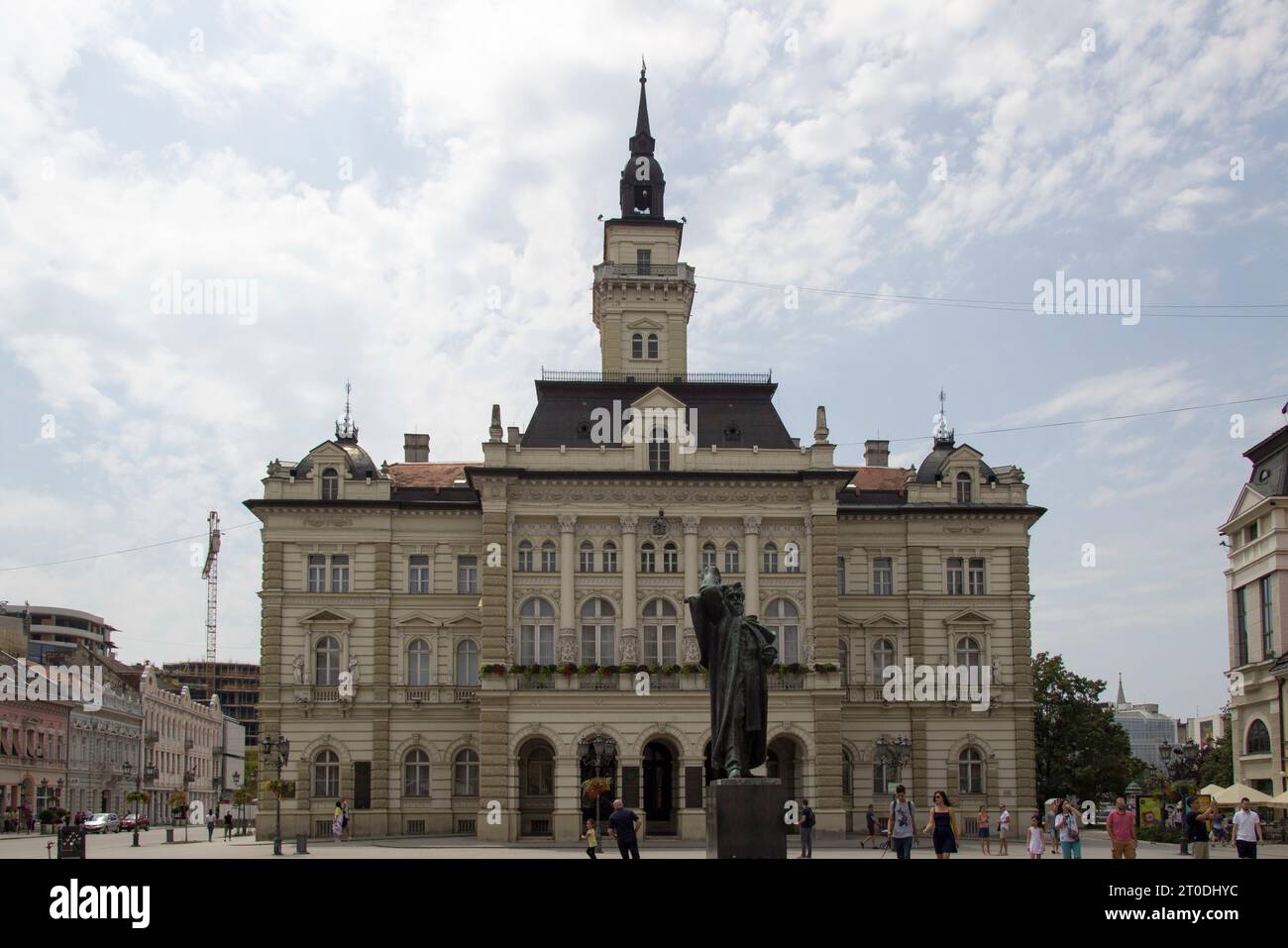 Una figura imponente di un uomo, che si erge orgogliosamente nella piazza della città tra la grandiosa architettura e le nuvole nel cielo, a simboleggiare il potere e la g Foto Stock