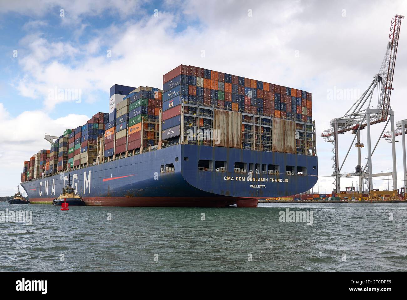 I tug SVITZER guidano la nave portacontainer di dimensioni ultra grandi, CMA CGM BENJAMIN FRANKLIN al suo ormeggio presso il terminal container di Southampton, Regno Unito Foto Stock