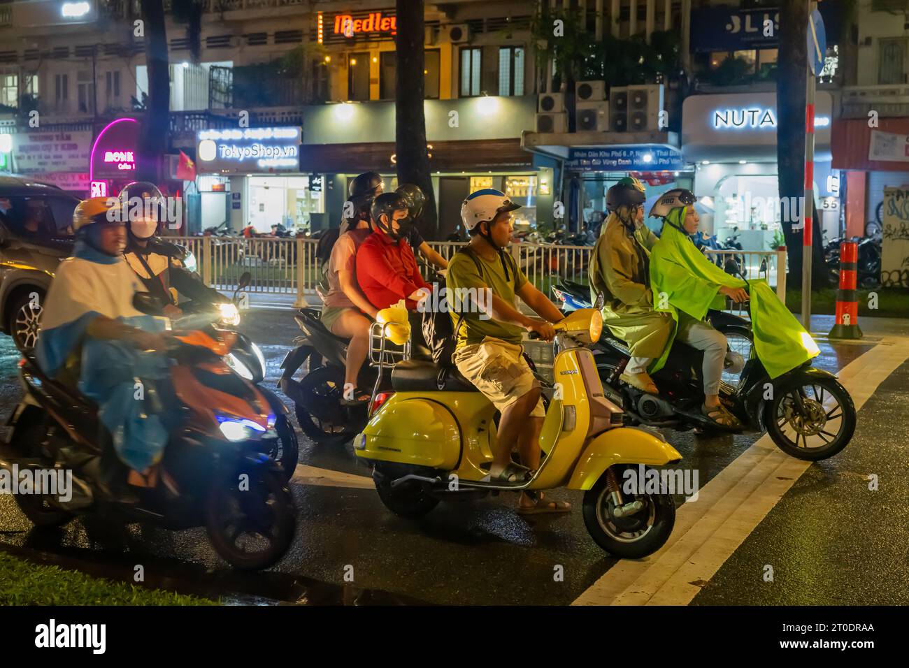 Scooter Viernamese in attesa al semaforo di notte, ho chi Minh City, Vietnam Foto Stock